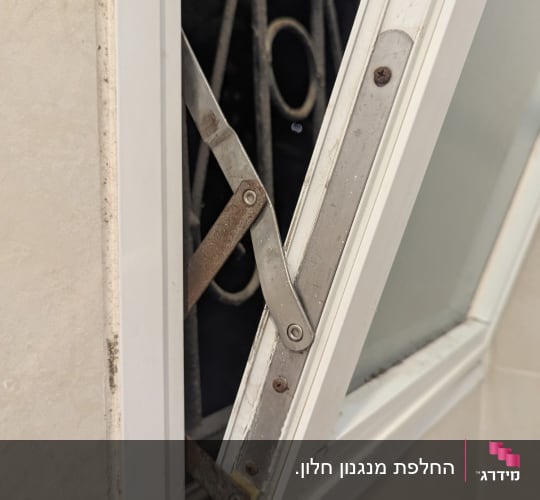 חלון פתוח עם מנגנון מתכת לתריסים